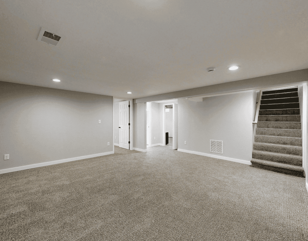 Finished basement space in Rexburg, Idaho with carpet flooring, recessed lighting, and stair access