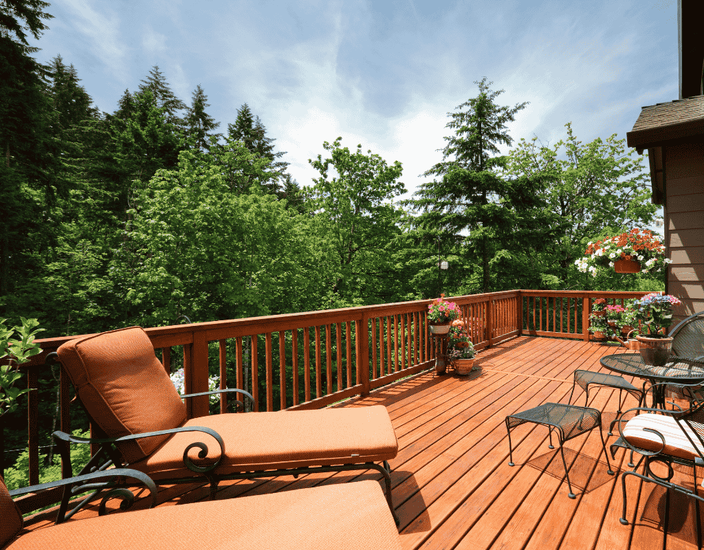 Elevated wood deck in Rexburg, Idaho with railing, outdoor seating, and scenic backyard views