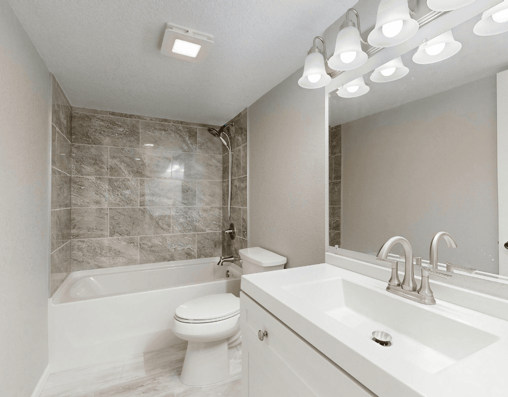 Newly renovated bathroom in Rexburg, ID with tile shower surround, updated vanity, and modern fixtures